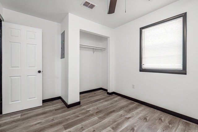 unfurnished bedroom featuring hardwood / wood-style flooring, ceiling fan, and a closet