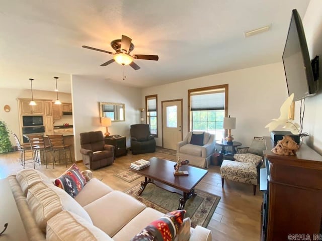 living room with ceiling fan and light hardwood / wood-style floors