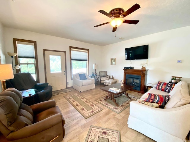 living room with a healthy amount of sunlight, ceiling fan, and light wood-type flooring