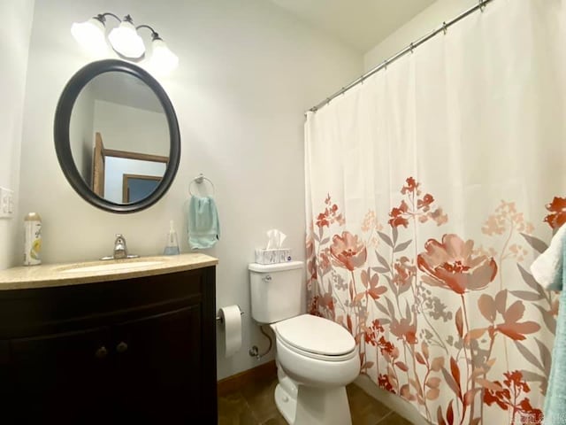 bathroom featuring tile patterned flooring, toilet, and vanity