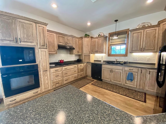 kitchen featuring light hardwood / wood-style flooring, decorative light fixtures, sink, black appliances, and tasteful backsplash