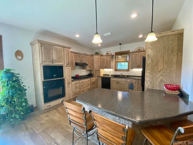 kitchen with light hardwood / wood-style floors, sink, black appliances, kitchen peninsula, and a kitchen breakfast bar