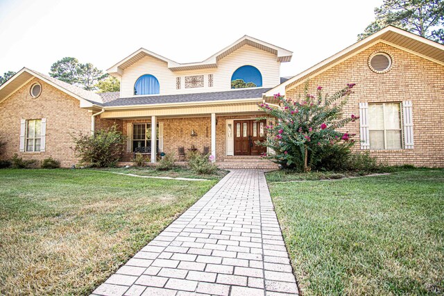 view of property featuring a front lawn and covered porch