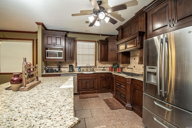 kitchen with tasteful backsplash, crown molding, stainless steel appliances, and a sink