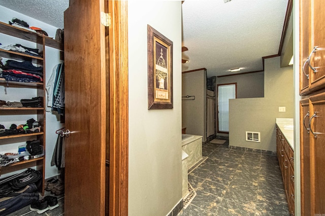 hallway with visible vents and a textured ceiling