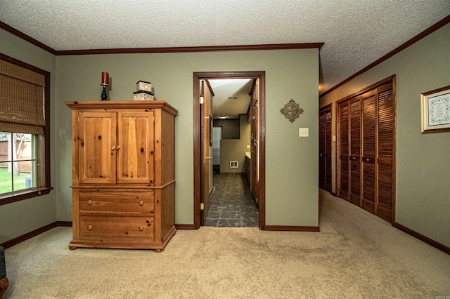 hall featuring light colored carpet, crown molding, and a textured ceiling