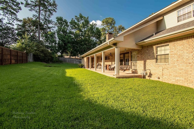 view of yard featuring a fenced backyard, a ceiling fan, and a patio