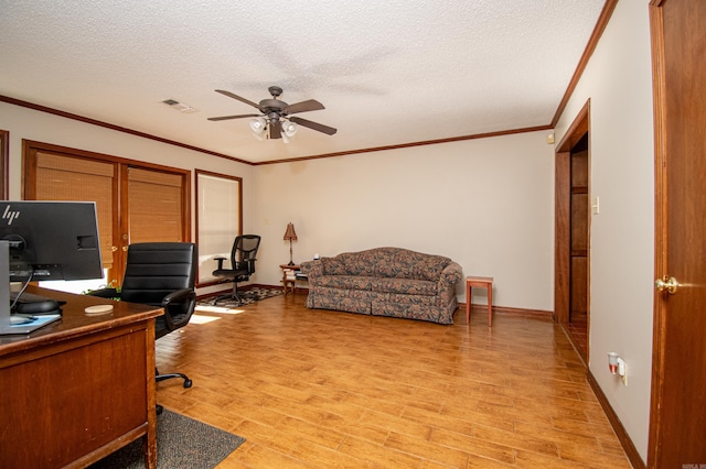 office with light wood finished floors, visible vents, a ceiling fan, ornamental molding, and a textured ceiling