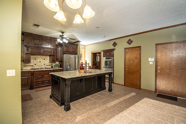 kitchen with ceiling fan, stainless steel appliances, a kitchen island, visible vents, and a kitchen breakfast bar