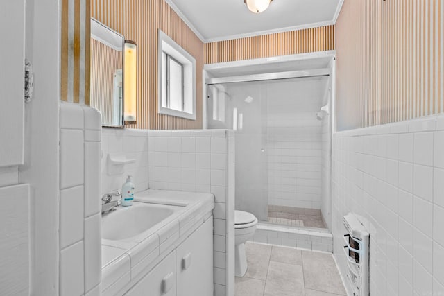 bathroom featuring tile patterned flooring, toilet, a tile shower, tile walls, and vanity