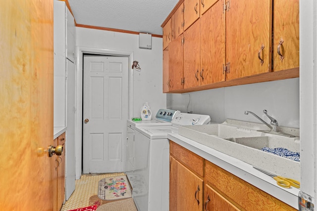 laundry area featuring washing machine and dryer, crown molding, cabinets, and a textured ceiling