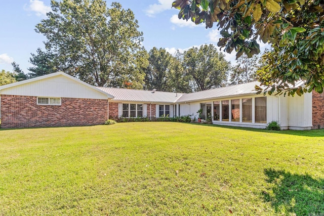 rear view of property featuring a yard