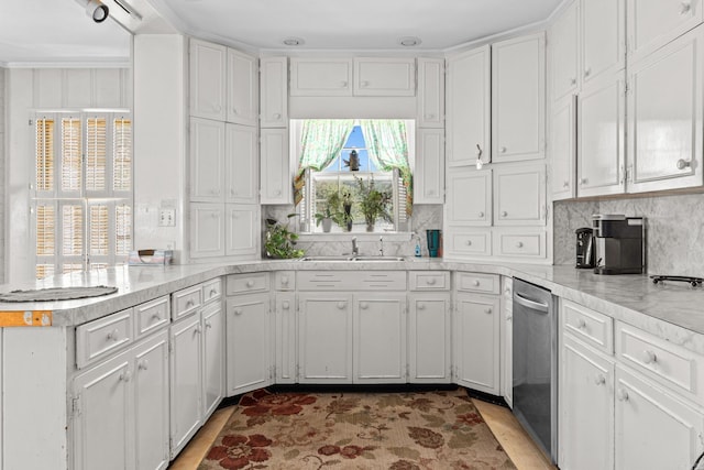 kitchen with tasteful backsplash, sink, white cabinets, and dishwasher