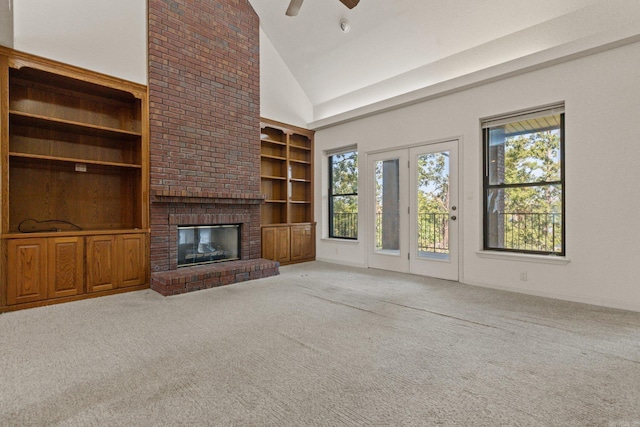 unfurnished living room with a fireplace, carpet floors, built in features, high vaulted ceiling, and ceiling fan