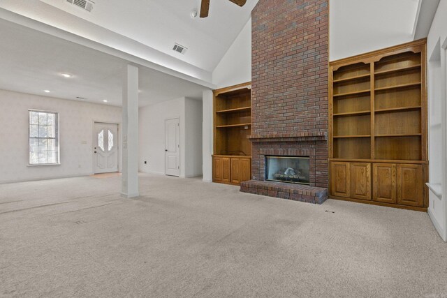 unfurnished living room featuring a brick fireplace, light carpet, ceiling fan, built in features, and high vaulted ceiling