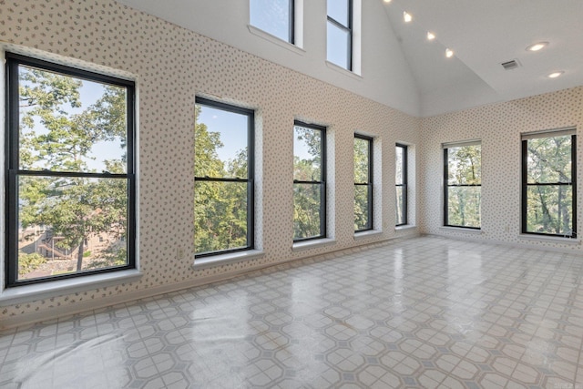empty room with vaulted ceiling, visible vents, and recessed lighting