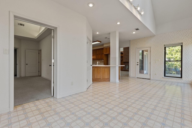 empty room featuring light colored carpet, sink, and vaulted ceiling