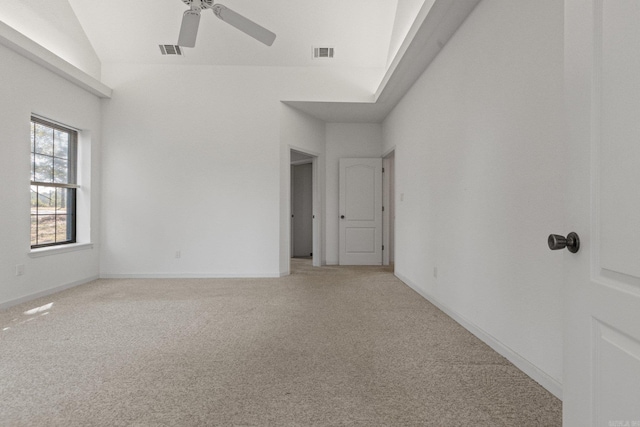 empty room with ceiling fan, light colored carpet, and vaulted ceiling