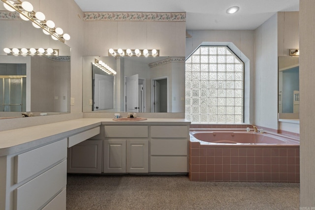 bathroom with vanity, a shower with shower door, and a garden tub