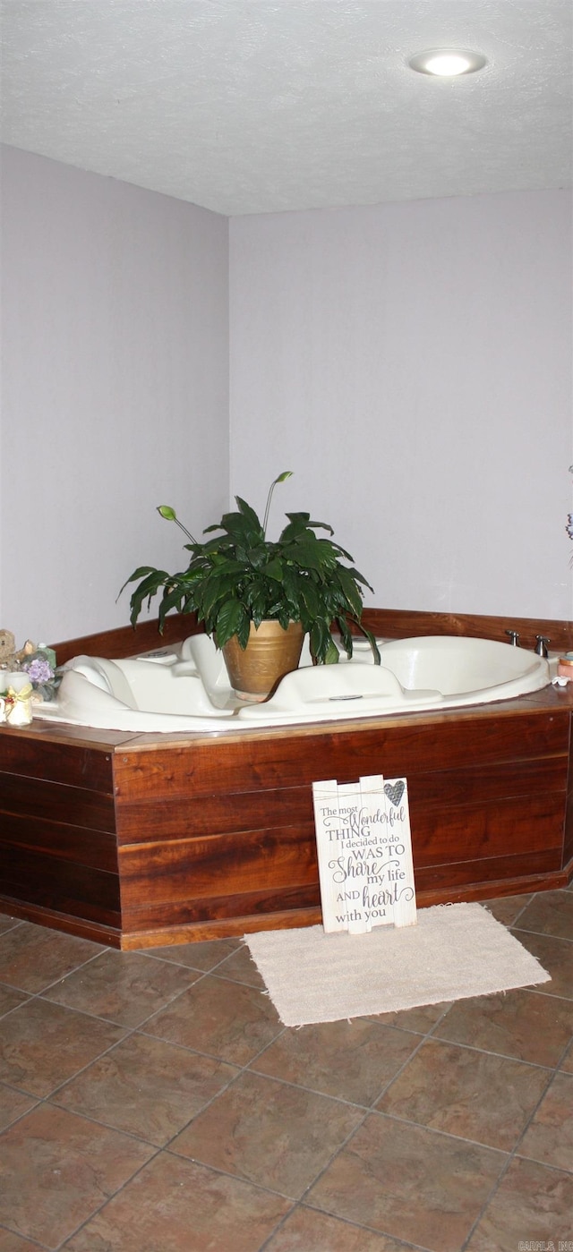 bathroom featuring a washtub and a textured ceiling