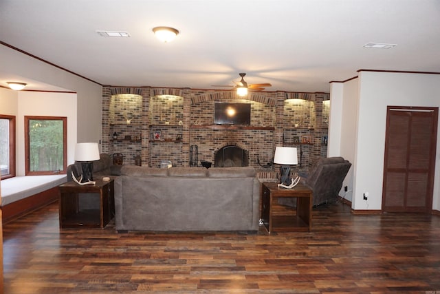 living room with a fireplace, ornamental molding, dark hardwood / wood-style flooring, and ceiling fan