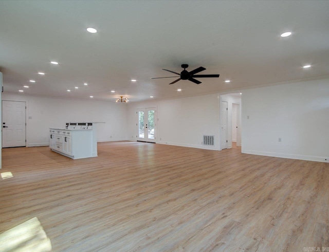 unfurnished living room with french doors, light wood-type flooring, ceiling fan, and crown molding