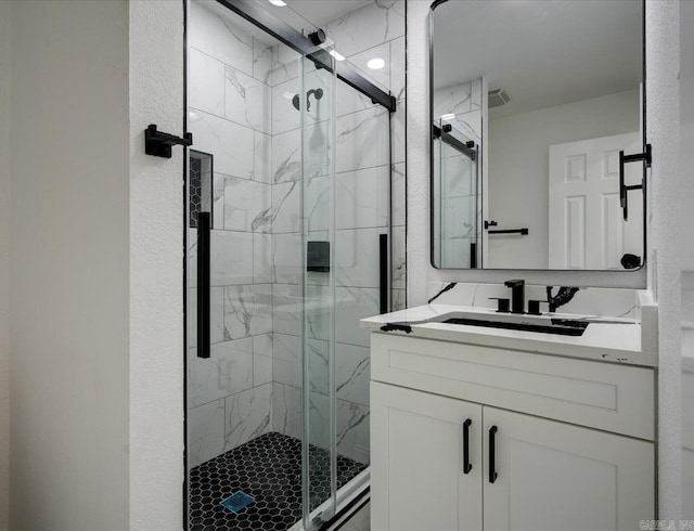 bathroom with vanity and a shower with door