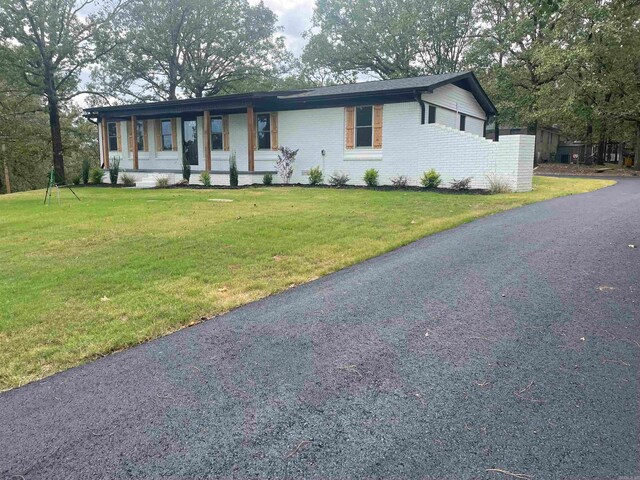 single story home featuring a front lawn and covered porch