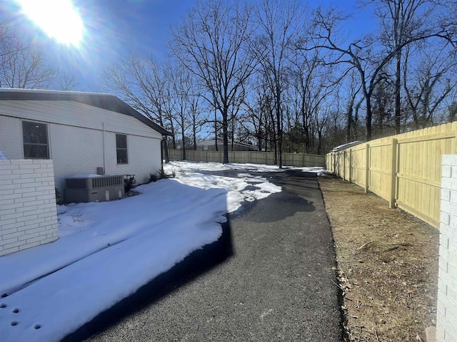 yard layered in snow featuring central AC unit