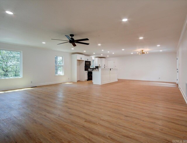 unfurnished living room with ceiling fan, light wood-type flooring, and ornamental molding