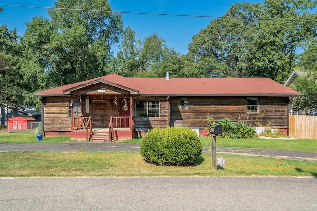 ranch-style home with a front yard and covered porch