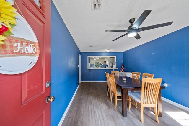 dining room featuring a textured ceiling, ceiling fan, and hardwood / wood-style flooring