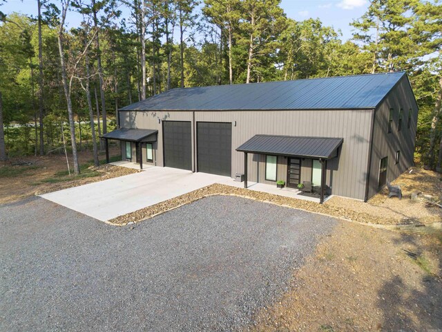 211 Woodland Shores Cir, Clinton, AR 72031 - view of front facade with driveway, metal roof, a garage, and an outbuilding