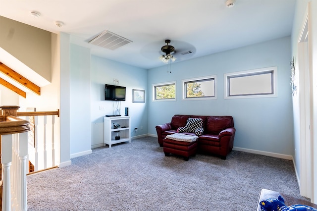 sitting room featuring ceiling fan, carpet, and beam ceiling