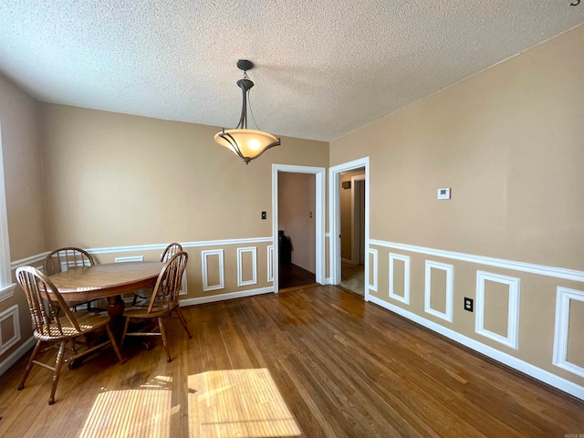 dining room featuring dark hardwood / wood-style floors and a textured ceiling