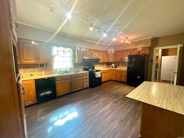 kitchen featuring black appliances, dark hardwood / wood-style flooring, sink, and a textured ceiling