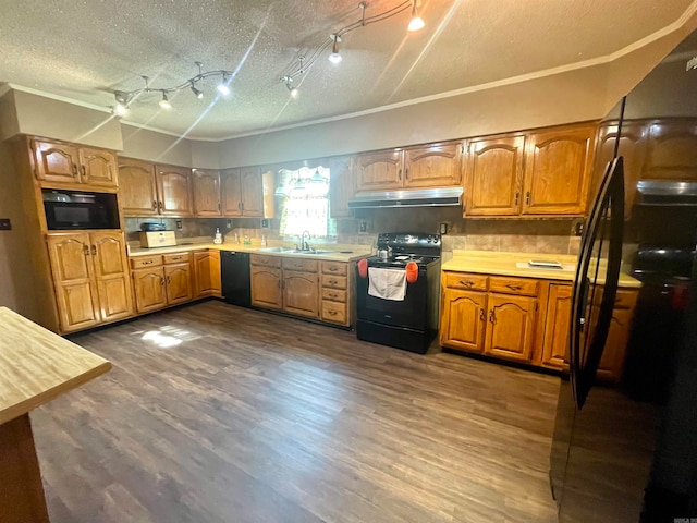 kitchen featuring black appliances, hardwood / wood-style flooring, sink, and a textured ceiling