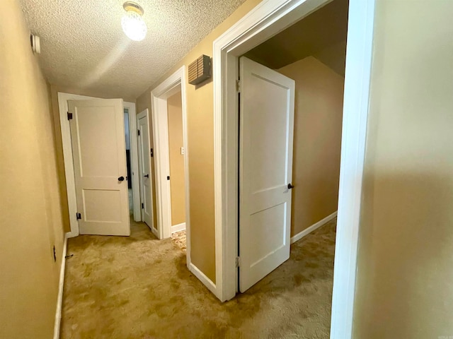 hall featuring light carpet, a textured ceiling, and lofted ceiling