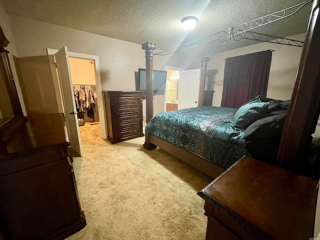 carpeted bedroom with a closet, a spacious closet, and a textured ceiling