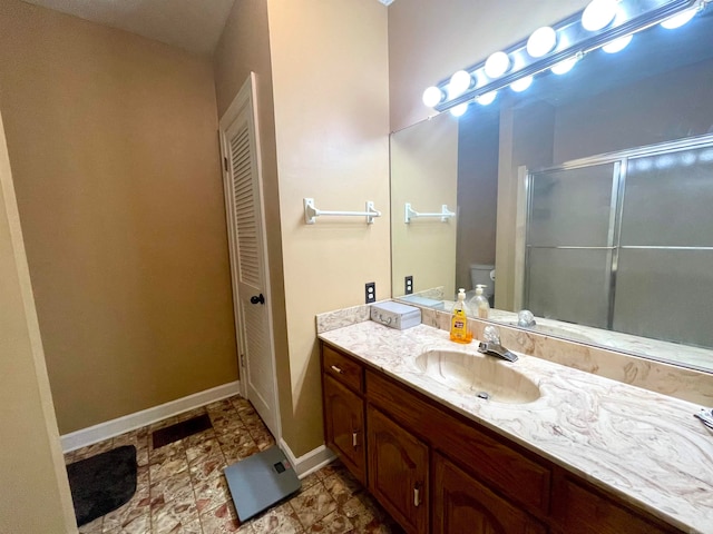 bathroom with vanity, toilet, and walk in shower