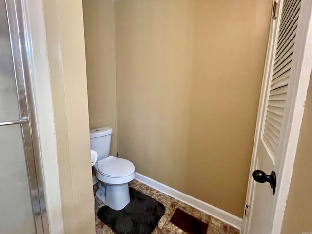 bathroom with an enclosed shower and toilet