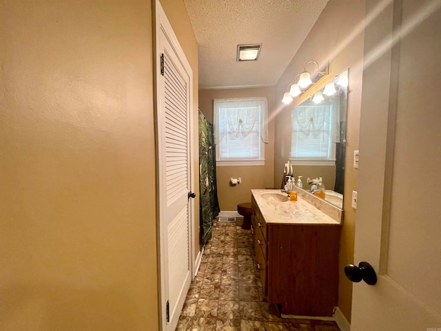 bathroom featuring curtained shower, a textured ceiling, and vanity