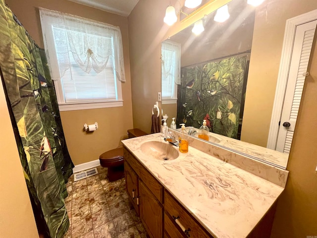 bathroom featuring vanity, toilet, and walk in shower