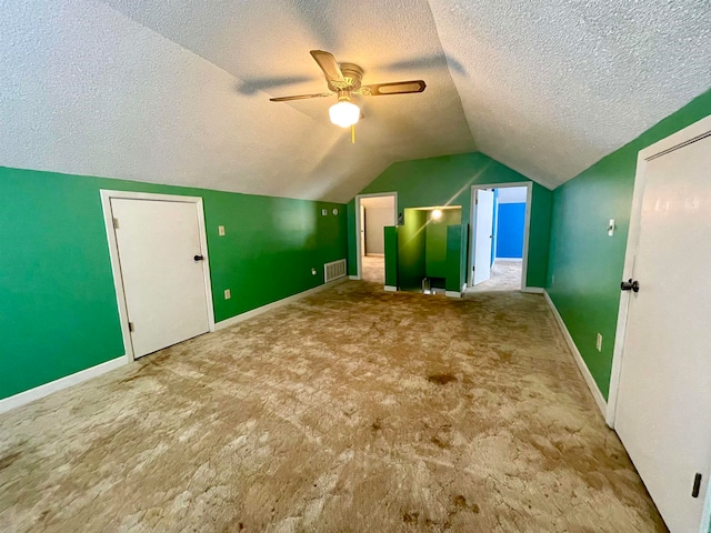 additional living space featuring lofted ceiling, ceiling fan, and a textured ceiling