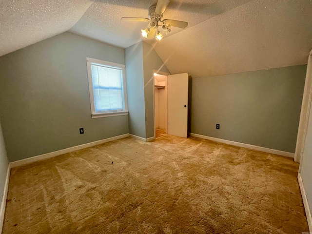 bonus room featuring light colored carpet, vaulted ceiling, a textured ceiling, and ceiling fan