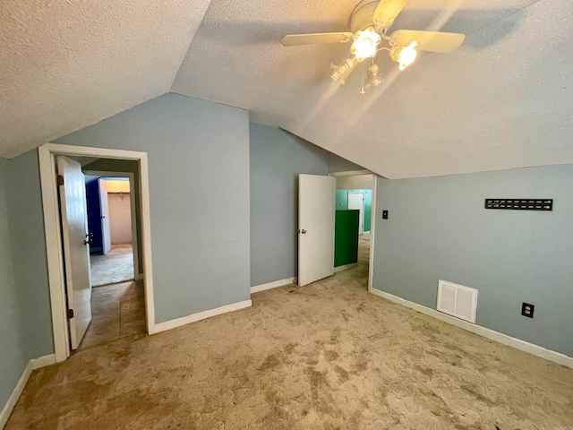 bonus room with a textured ceiling, light colored carpet, ceiling fan, and vaulted ceiling