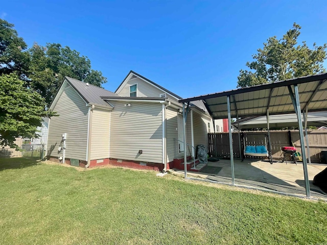 rear view of house featuring a lawn and a patio area