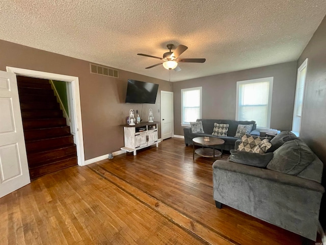 living room with a textured ceiling, ceiling fan, and hardwood / wood-style floors