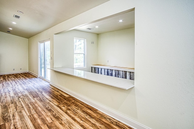 unfurnished room with recessed lighting, visible vents, baseboards, and wood finished floors