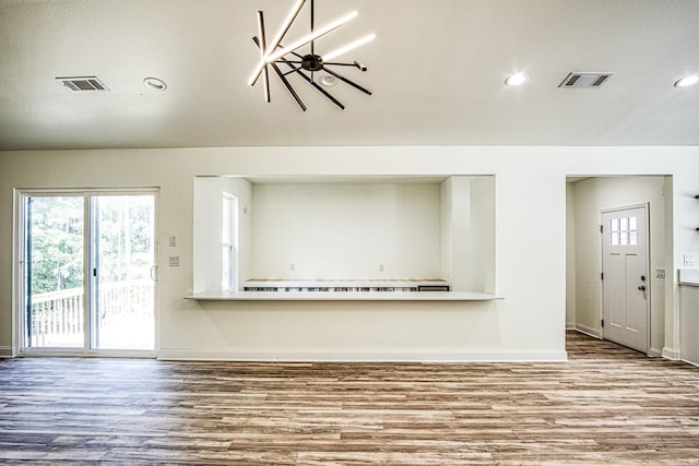 unfurnished living room with visible vents, baseboards, and wood finished floors
